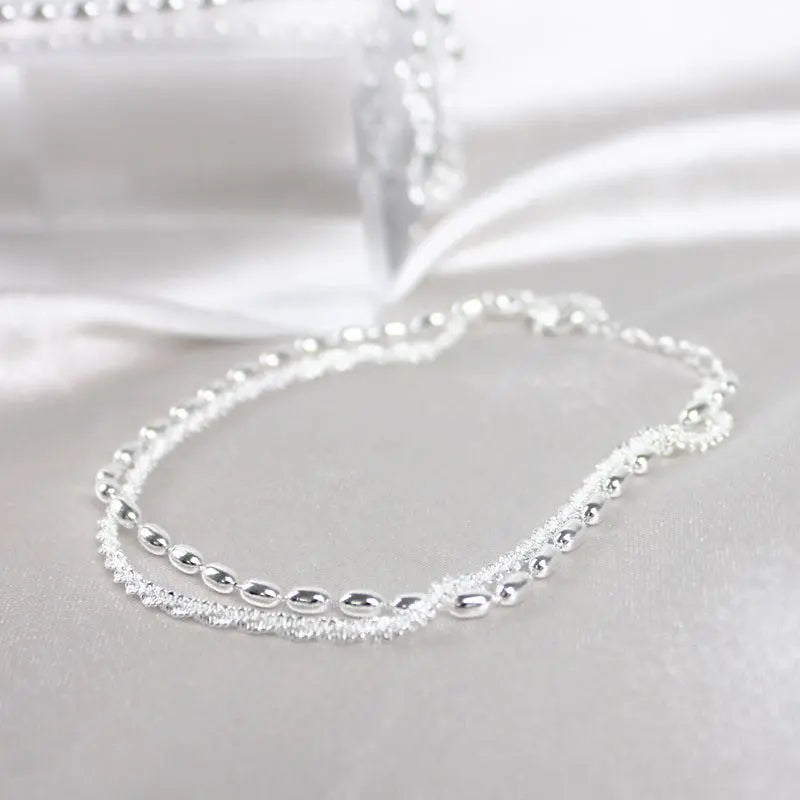 Elegantes Set aus silbernen Armbändern mit Zirkonsteinen
