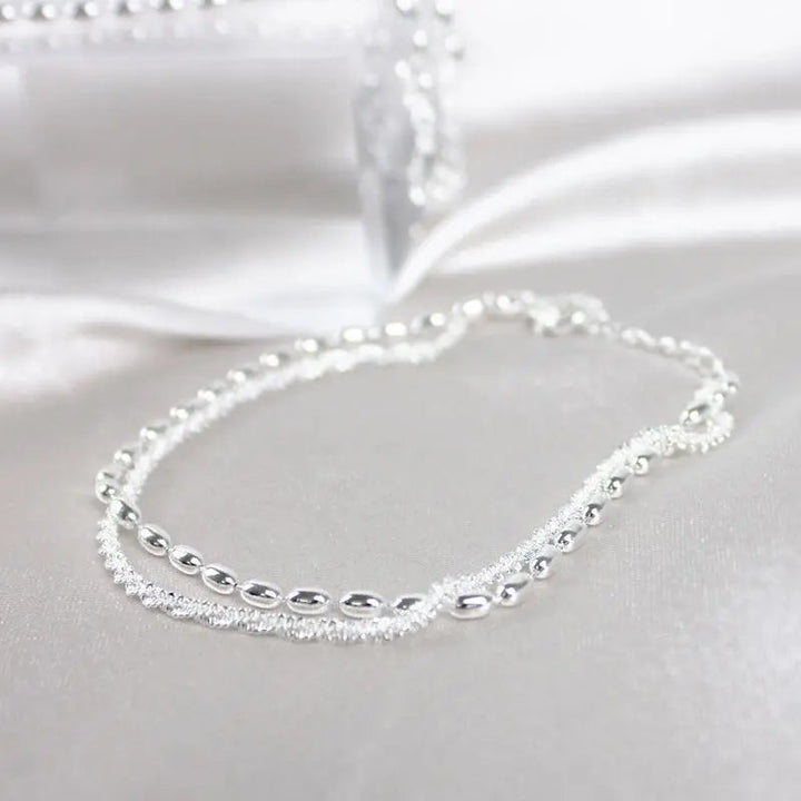 Elegantes Set aus silbernen Armbändern mit Zirkonsteinen