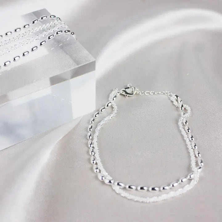 Elegantes Set aus silbernen Armbändern mit Zirkonsteinen