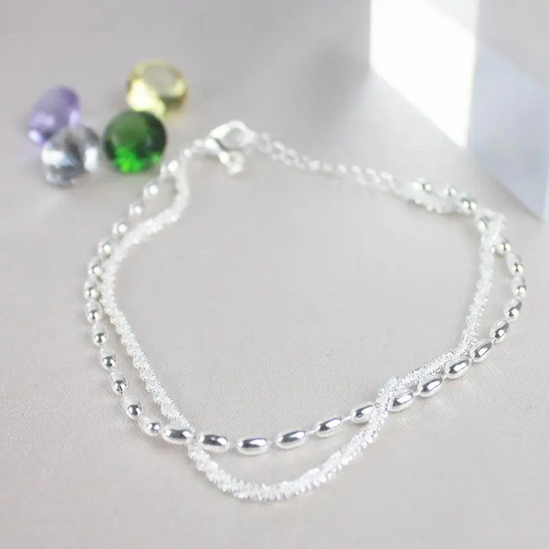 Elegantes Set aus silbernen Armbändern mit Zirkonsteinen