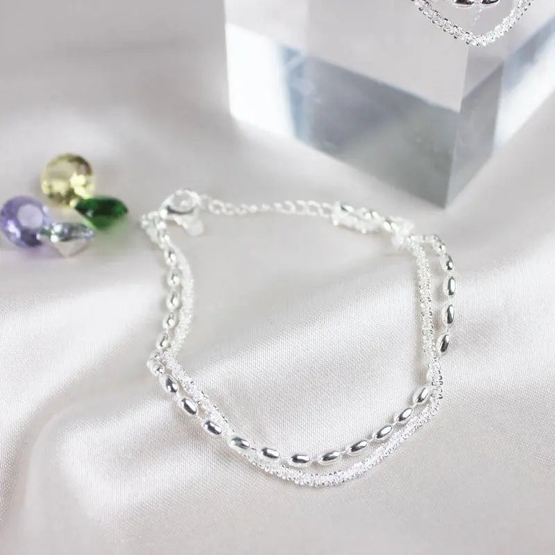 Elegantes Set aus silbernen Armbändern mit Zirkonsteinen