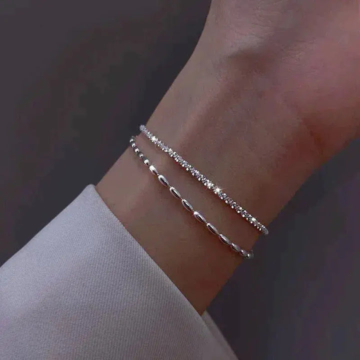 Elegantes Set aus silbernen Armbändern mit Zirkonsteinen